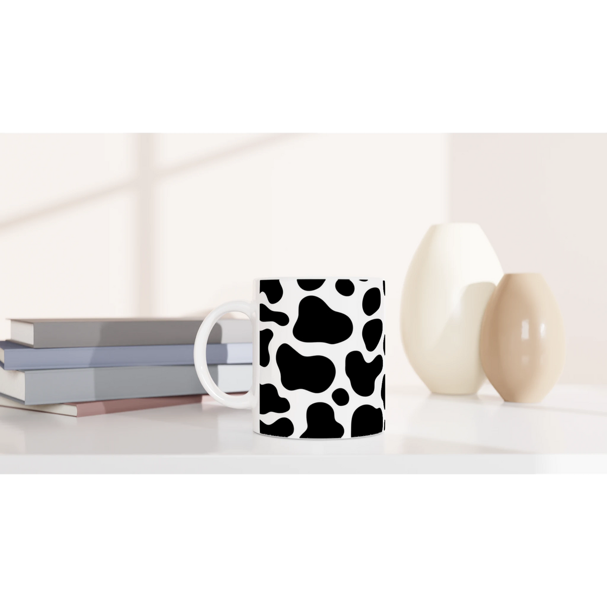 Black & white cow-print ceramic mug, a cute Y2K animal print coffee cup on a desk.
