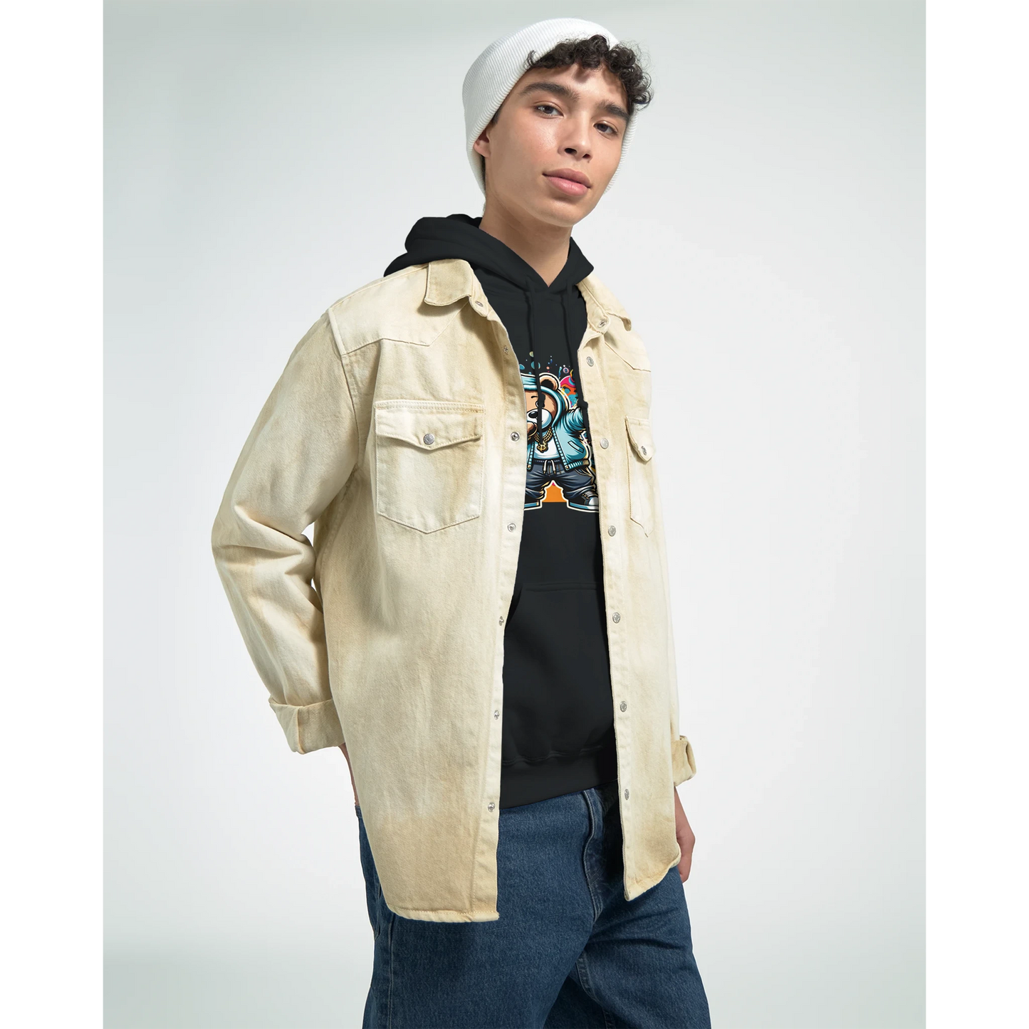 Person wearing a beige jacket over a black men's teddy bear hoodie with a colorful design, on a plain background