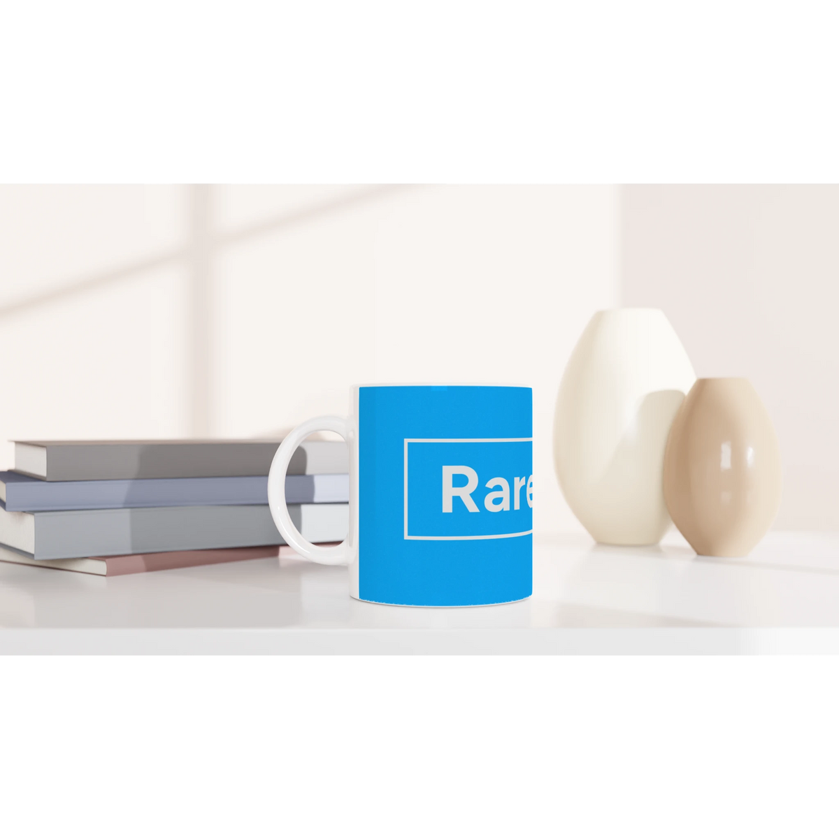 Blue Cute Rare Find mug on a desk with books, displaying the Rare Find slogan.