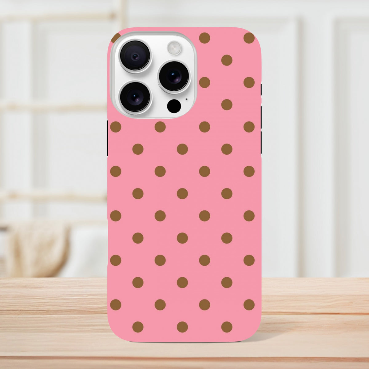 Pink and brown polka dot tough iPhone case featuring a cute glossy design with shock-absorbing TPU protection for models 13 through 16.