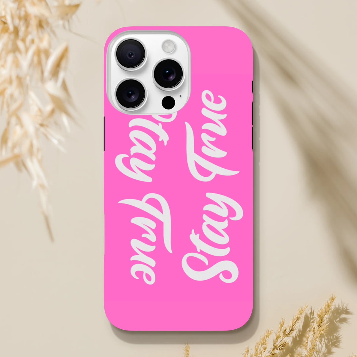 Pink tough iPhone case featuring white "Stay True" script text. Positive quote phone cover for iPhone 13-16.