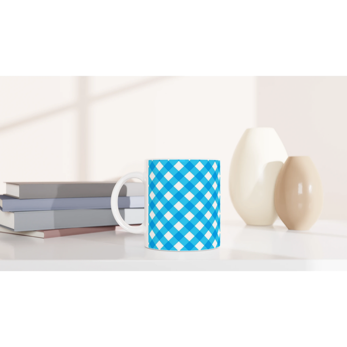 Blue checkered ceramic mug with white handle on a desk beside books and decor.