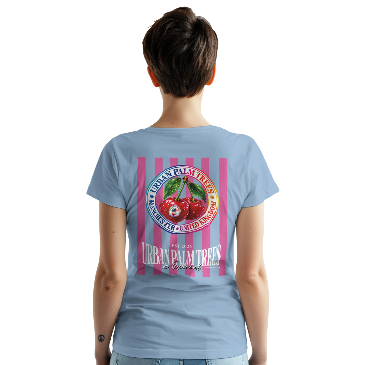 Back of light blue women's t-shirt featuring a large retro graphic of red cherries on pink vertical stripes with Urban Palm Trees text.