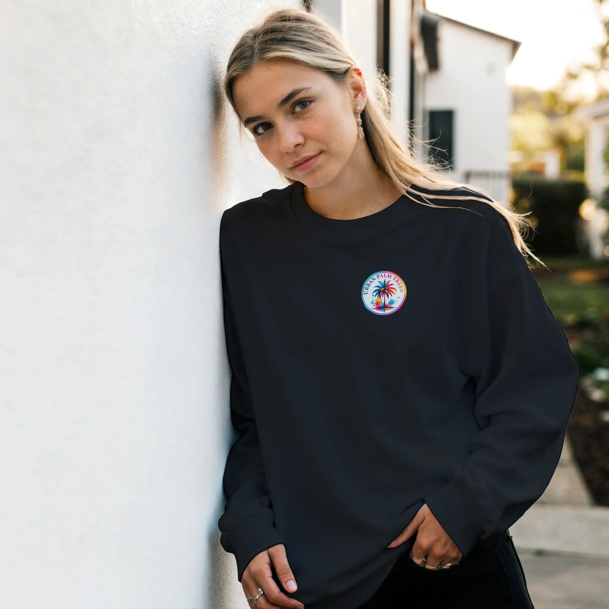 Woman wearing black vintage graphic tee with colorful tropical palm tree logo. Cozy streetwear top featuring retro urban print.