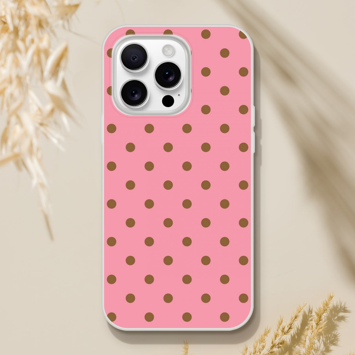 Retro pink iPhone case with brown polka dots. Flexible TPU phone cover for iPhone 13-16 series offering vintage style and impact protection.