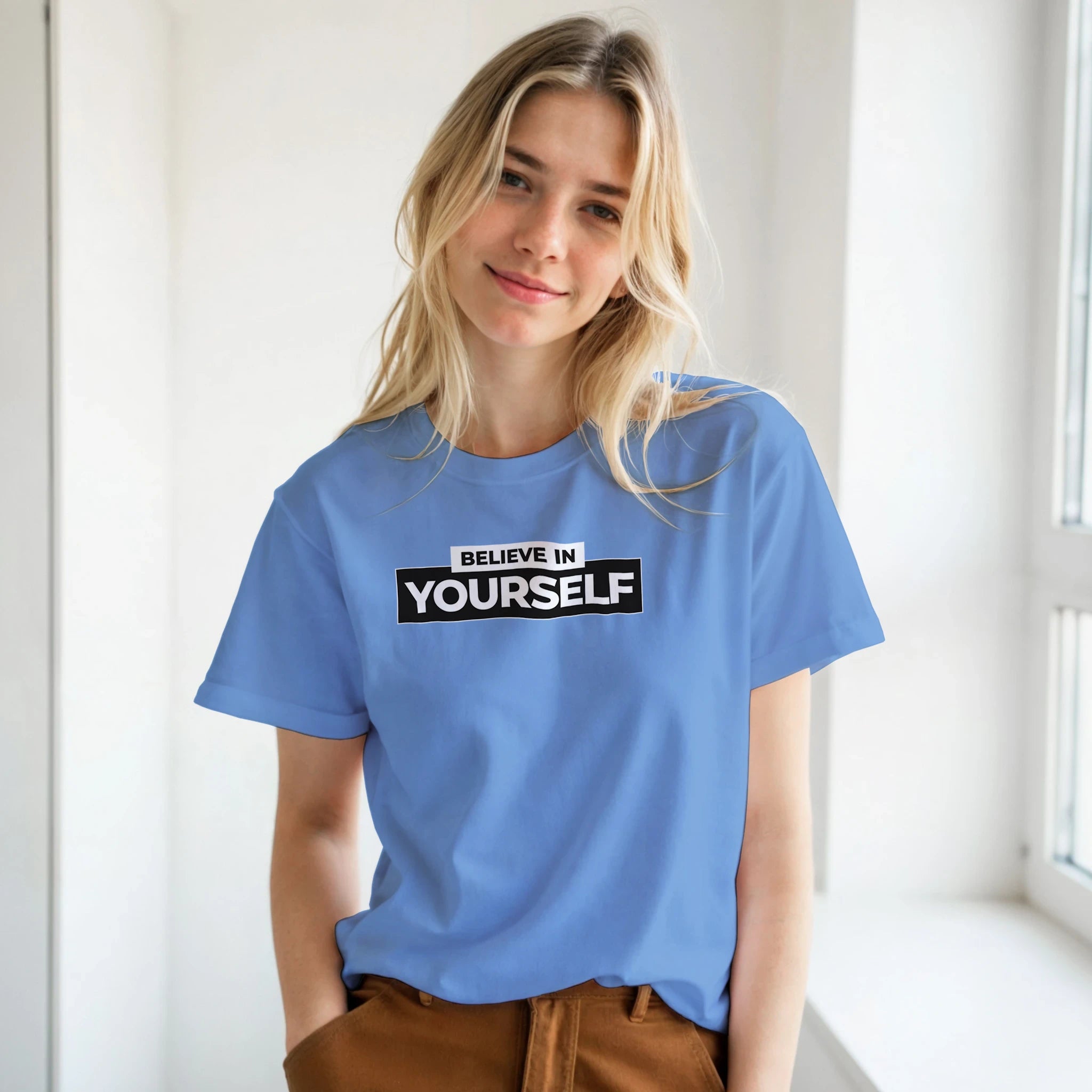 Young woman wearing a blue Believe In Yourself T-shirt with retro slogan.