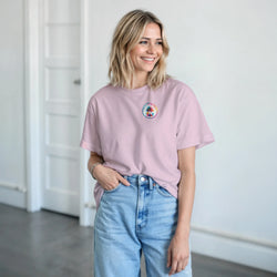 Pink retro summer t-shirt with small palm tree graphic, styled with high-waist jeans for a playful casual look.