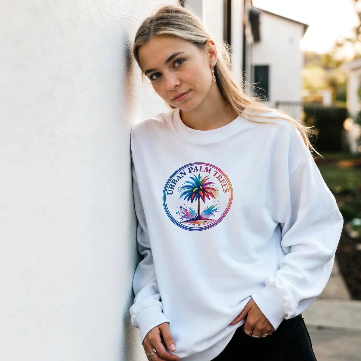 Woman wearing a white Urban Palm Trees Sweatshirt with a colorful palm graphic, retro aesthetic.
