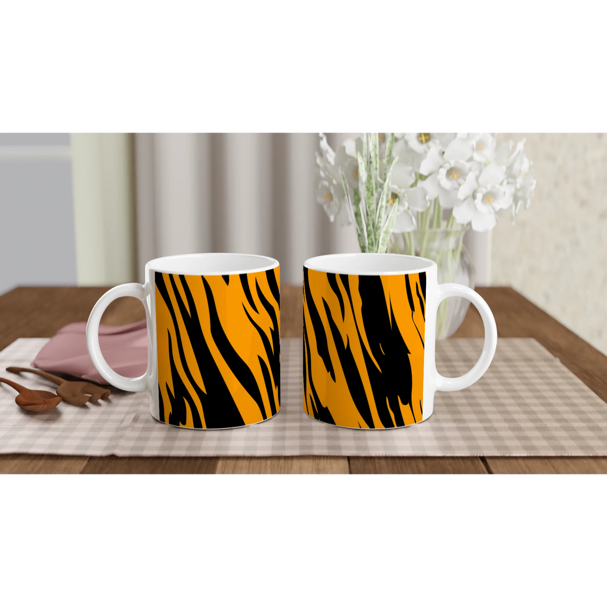 Two orange and black tiger-print mugs on a table, bold animal-print coffee cups.