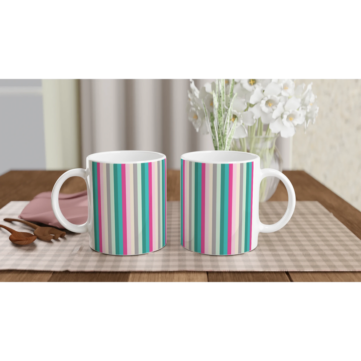 Pastel rainbow stripe ceramic mugs on a table, cute colorful coffee cups with white flowers in the background.