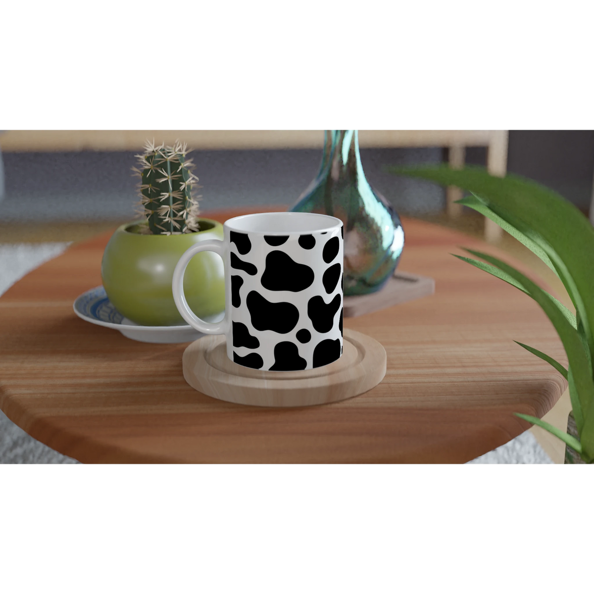 Cow-print black-and-white ceramic mug on a wooden table with plants nearby.