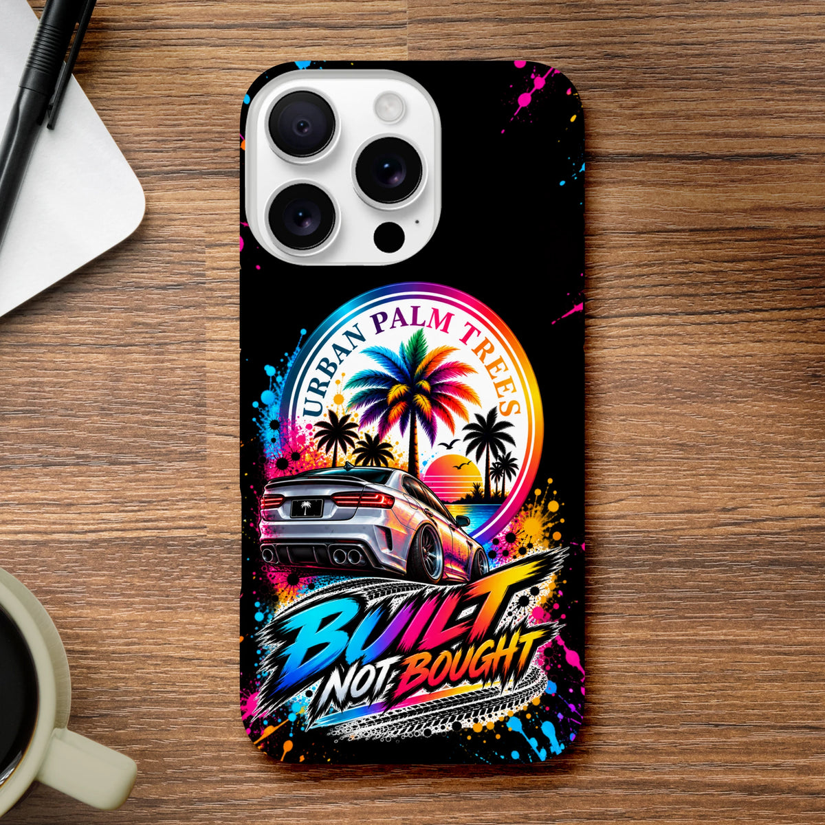 Built Not Bought iPhone case featuring a modified car, Urban Palm Trees logo, and colorful graffiti art.

(98 characters)
