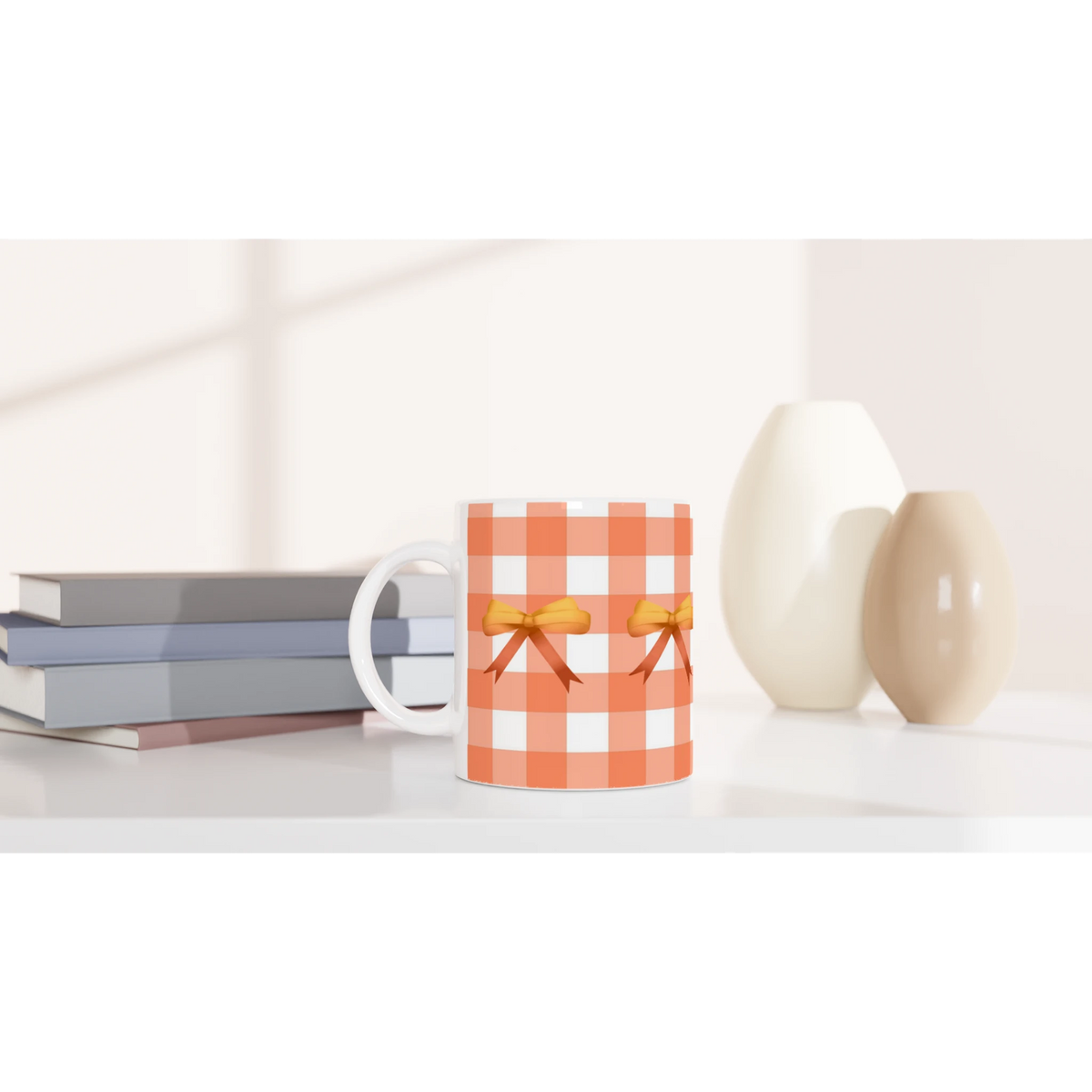 Orange gingham bow mug with white handle and bow accent, placed on a desk beside stacked books.