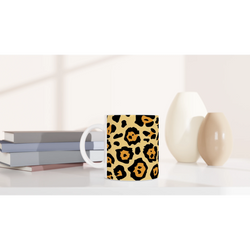 Classic leopard print mug on a white desk with pastel books and beige decor.