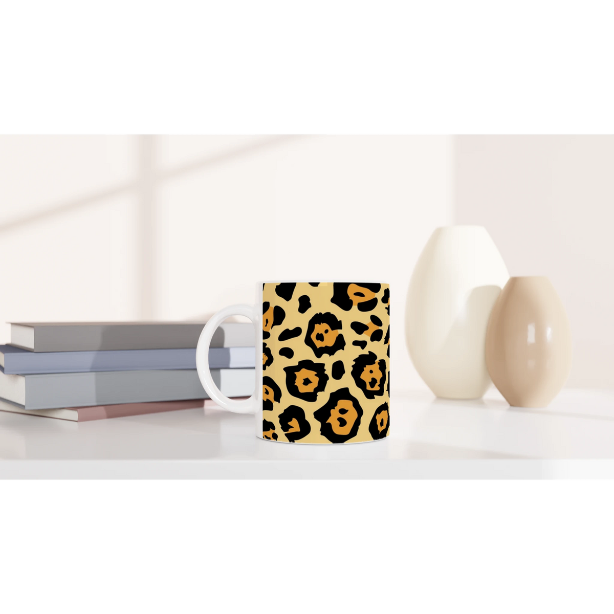 Classic leopard print mug on a white desk with pastel books and beige decor.