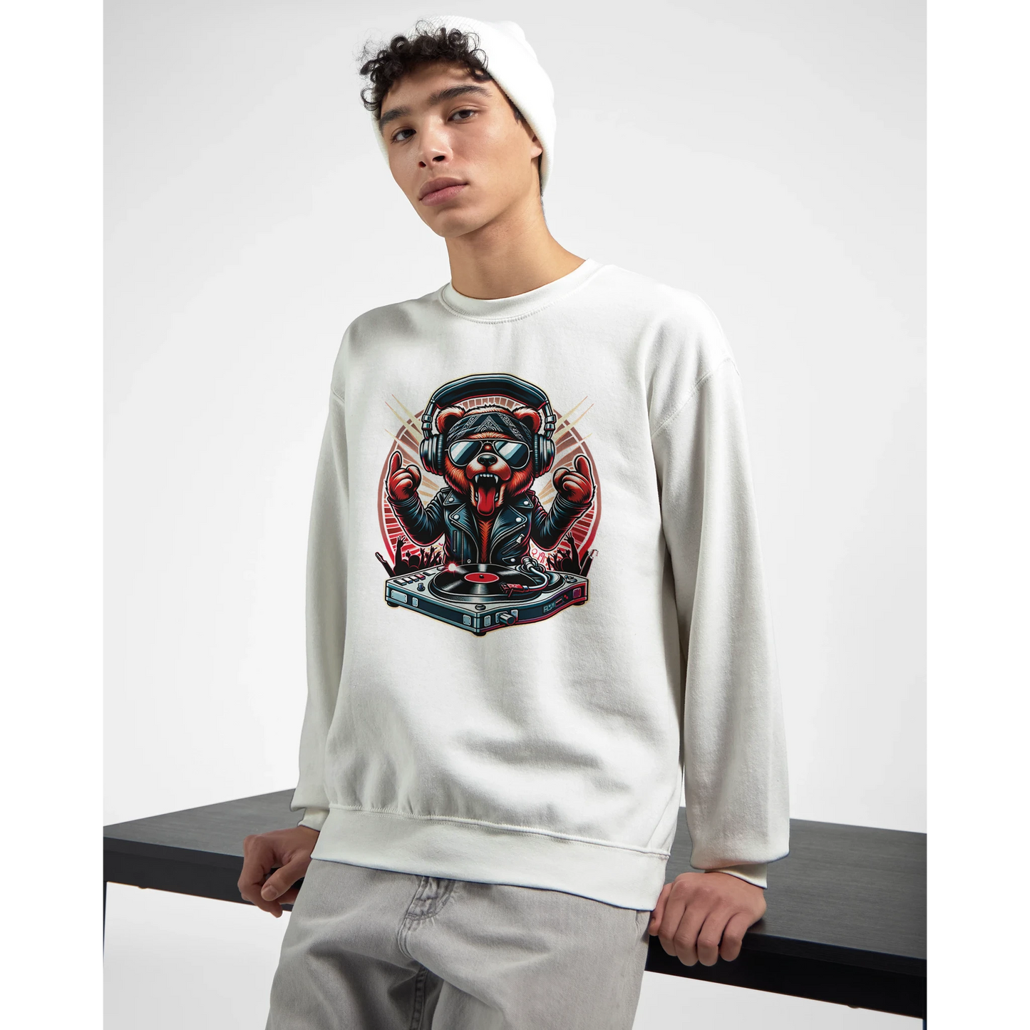 Person wearing a white men's graphic sweatshirt with a graphic design on a plain background. Sat on table.