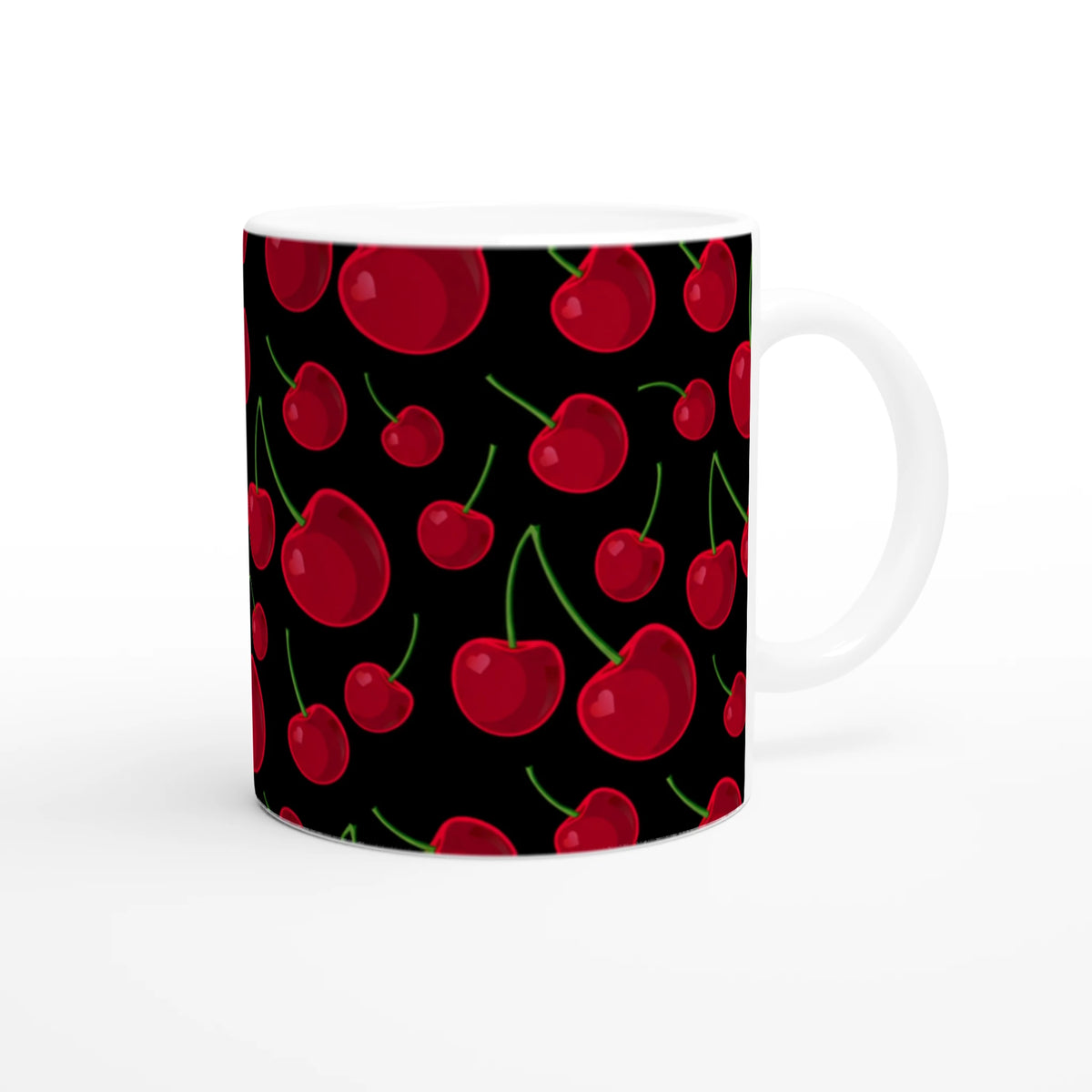 Black ceramic coffee mug featuring a vibrant retro pattern of red cherries with green stems.