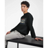 Young man wearing a black 50/50 cotton-poly Car Jumper JDM sweatshirt with a car graphic, seated at a table.