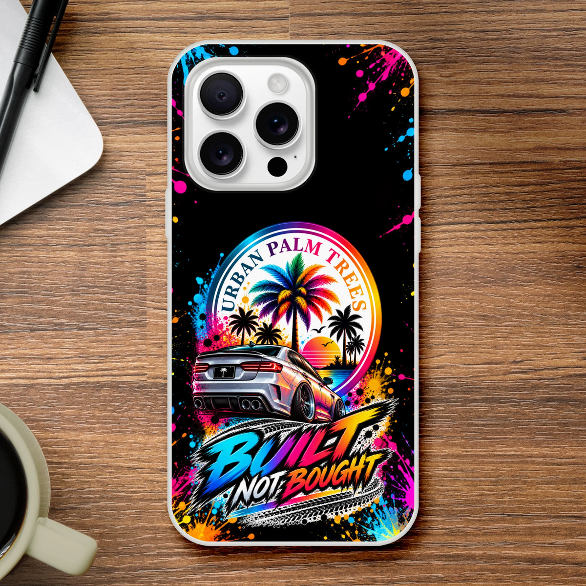 iPhone case featuring a silver modified car, Urban Palm Trees sunset, and colorful Built Not Bought graffiti art on a black background.