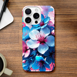 Vibrant blue and pink floral iPhone case on a wooden desk beside a coffee cup and pen.