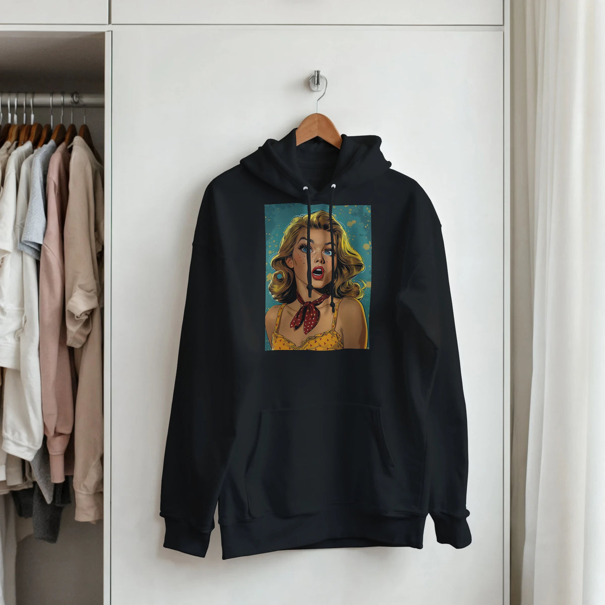 Black pullover hoodie featuring a retro pop art graphic of a blonde pin-up woman with a red bandana hanging on a wooden hanger.