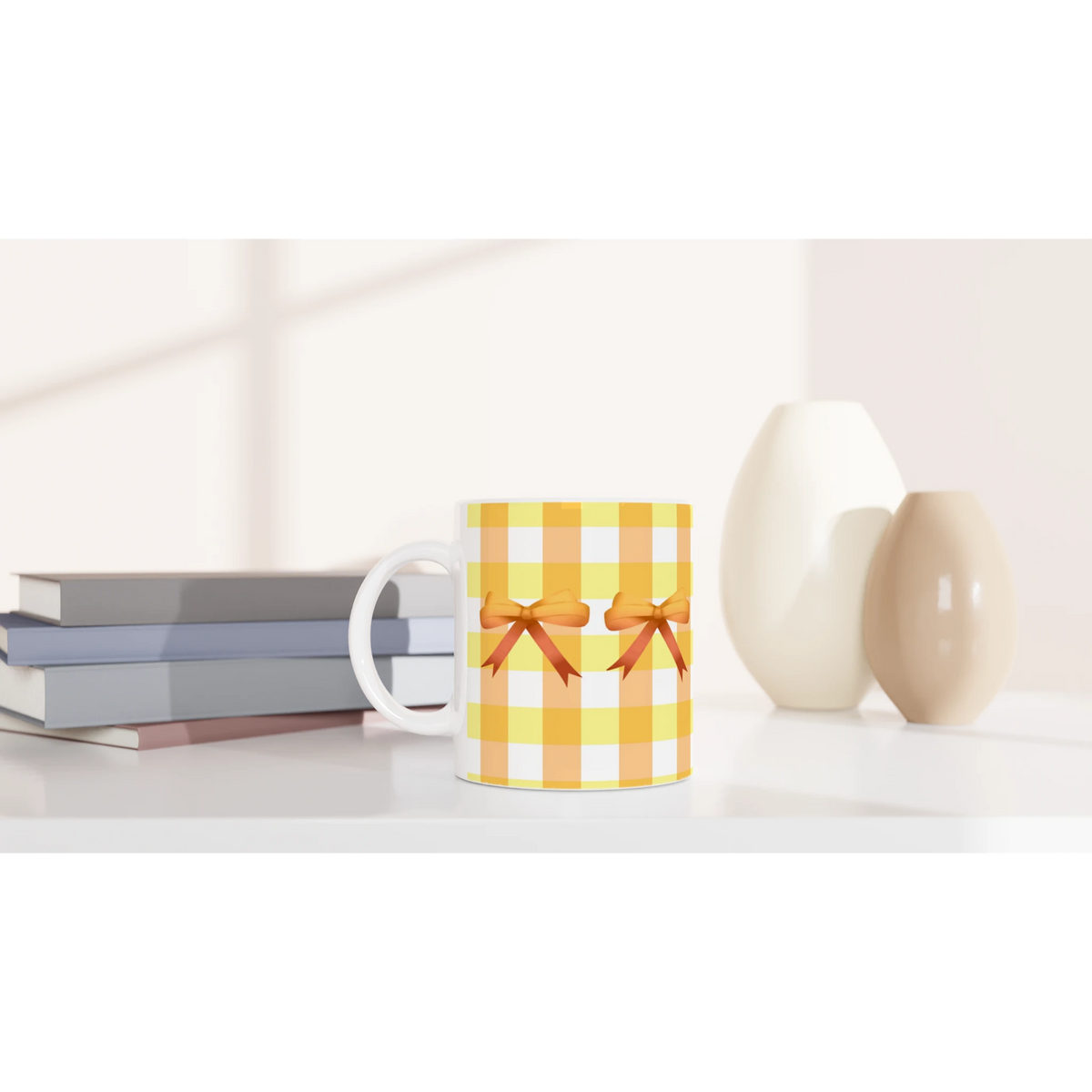 Yellow gingham bow mug on a white desk with gift boxes nearby.