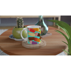 Retro popsicle pattern ceramic mug on wooden coaster. Colourful summer ice lolly coffee cup with vibrant frozen treats design.