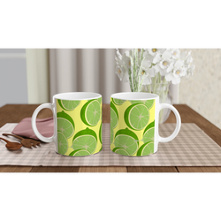 Two lime-slice patterned ceramic mugs with bright citrus design on a wooden table.