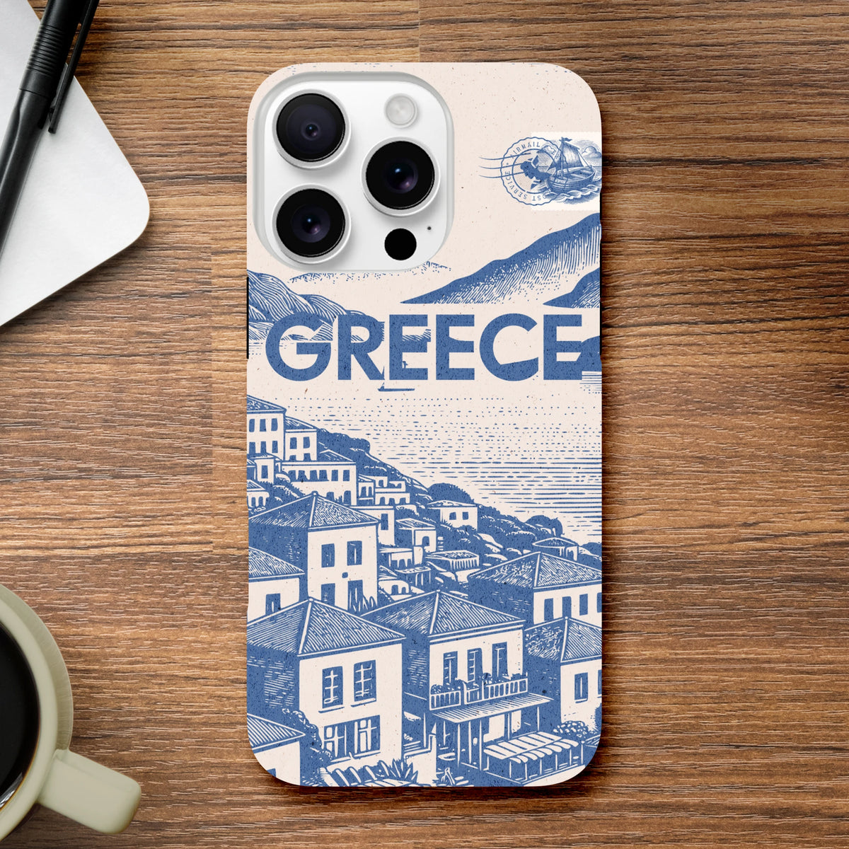 Vintage Greece phone case with blue Mediterranean village illustration, airmail stamp, and bold text on cream background.