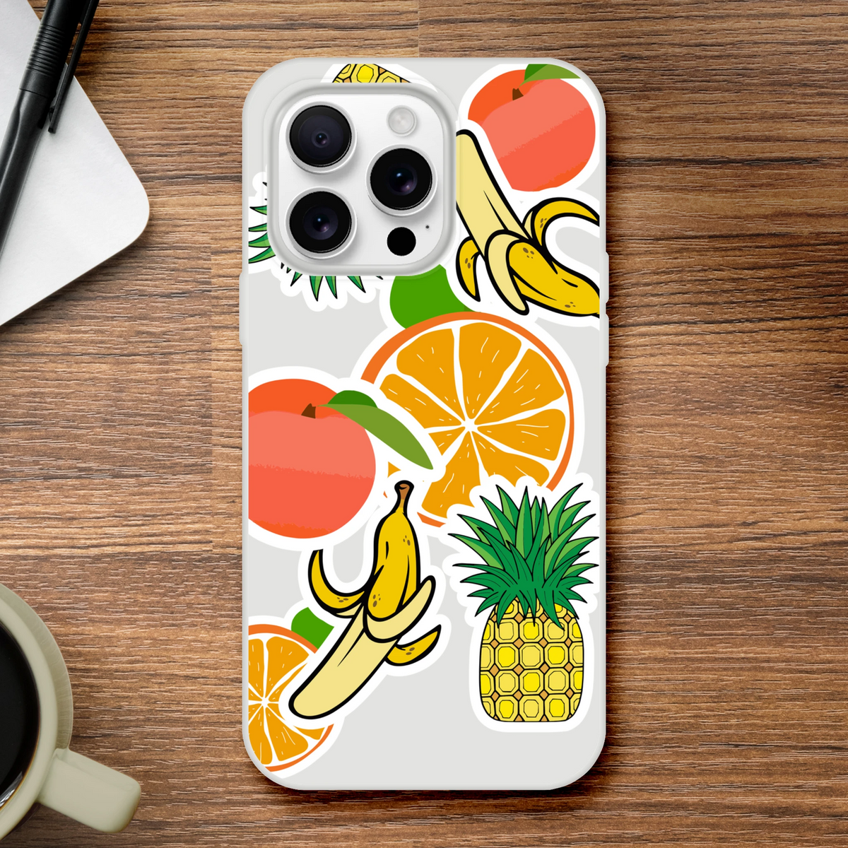 Clear iPhone case featuring bold sticker-style graphics of oranges, bananas, and pineapples for a tropical streetwear look.