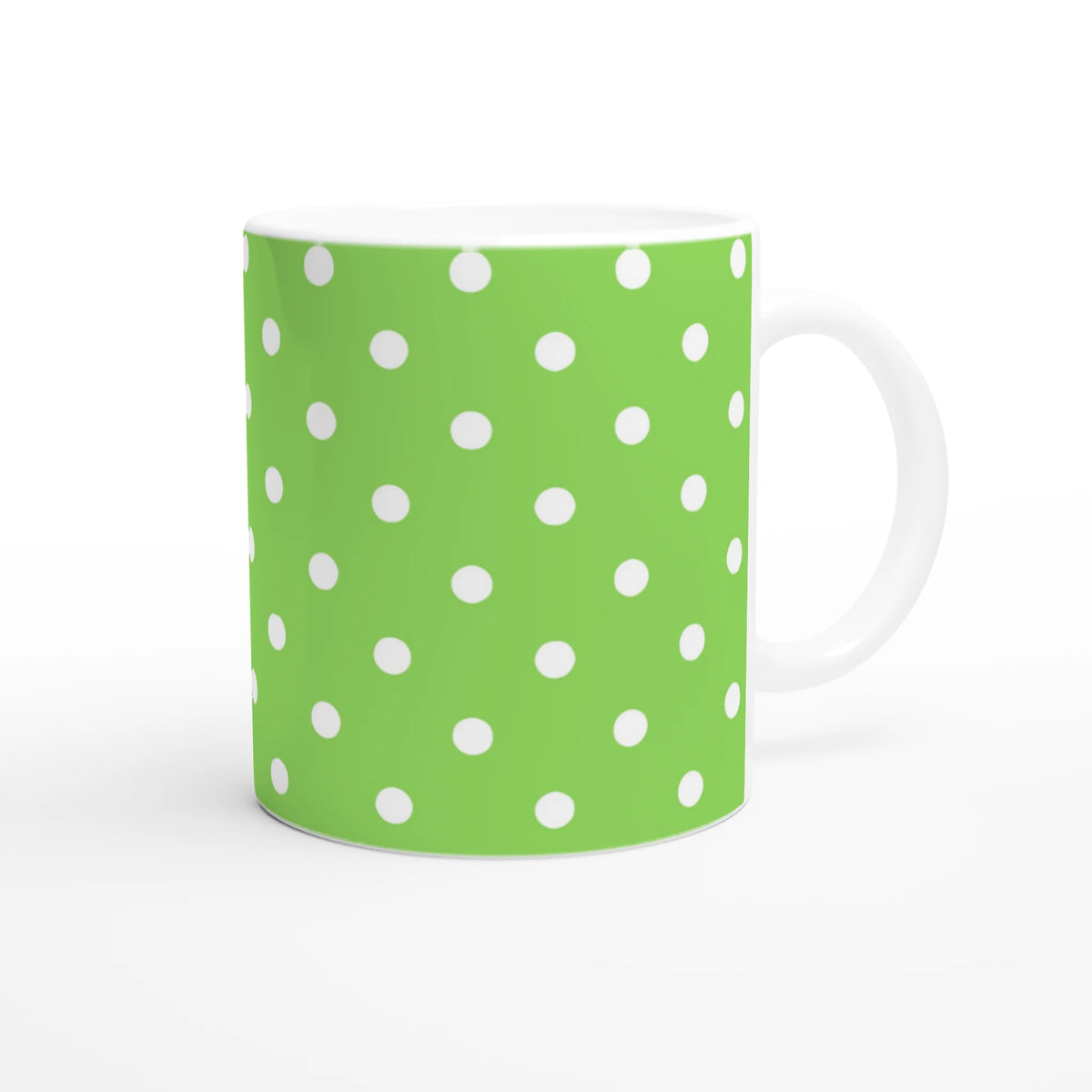 Green and white polka dot ceramic coffee mug with a vibrant spotty motif, ideal for daily use or gifting.