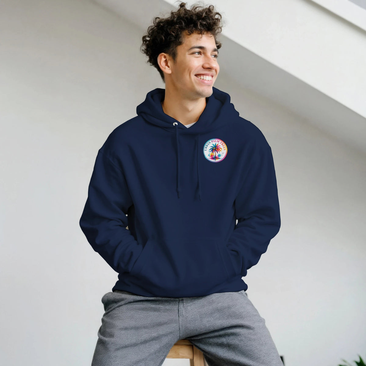 Man wearing navy blue retro music hoodie featuring a colorful Urban Palm Trees graphic on the chest and a front pouch pocket.