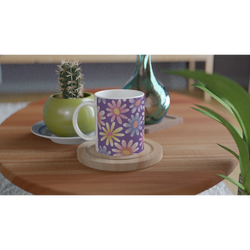 Retro Pastel Daisy Mug with purple floral design on a wooden table beside a cactus and green vase.
