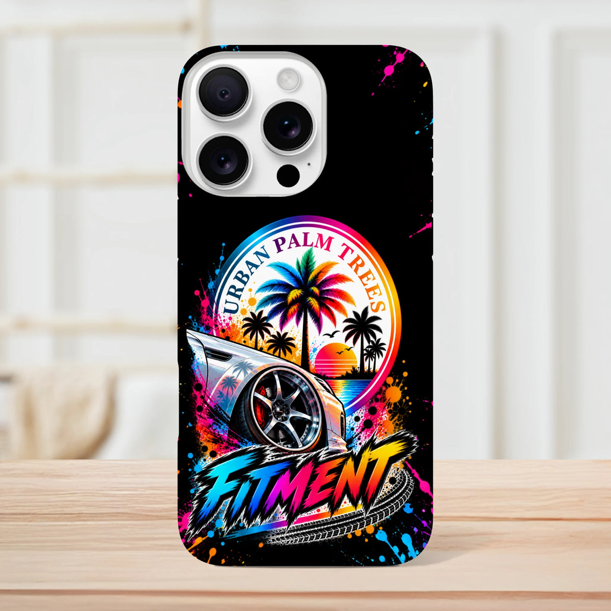 Fitment iPhone case with modified car, rainbow palm trees, Urban Palm Trees text, and colorful streetwear splatter art on black background.