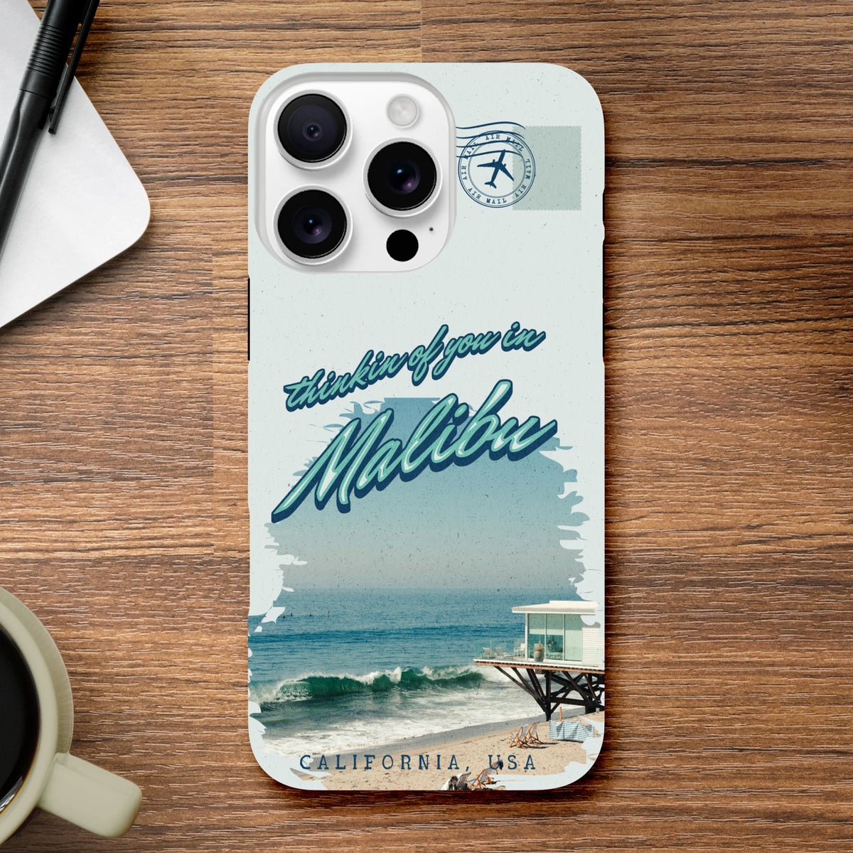 Vintage Malibu beach phone case with "thinkin of you in Malibu" text, pier graphic, and Air Mail stamp design for iPhone 13-16.