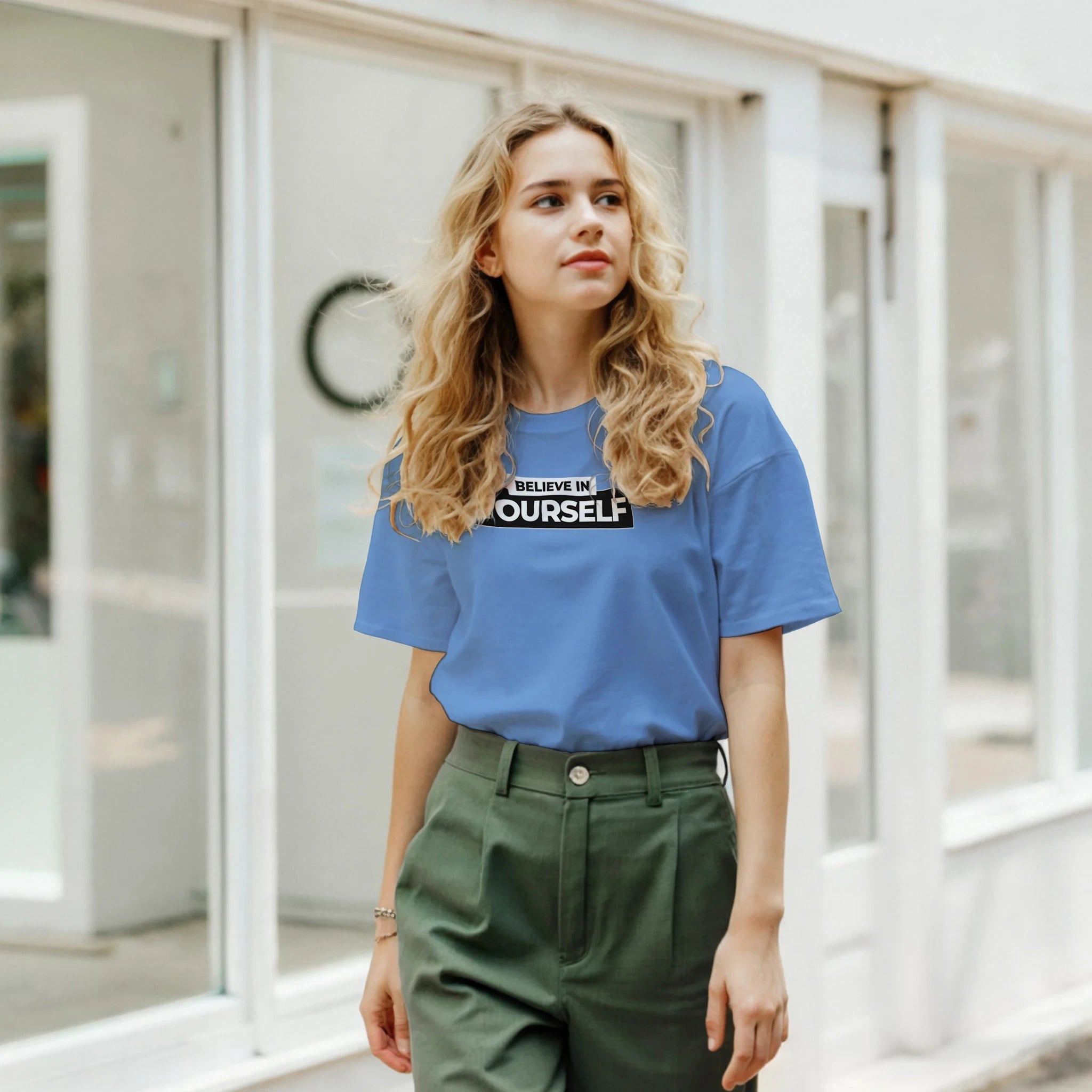Woman in blue Believe In Yourself retro slogan T-shirt, Urban Palm Trees streetwear style.