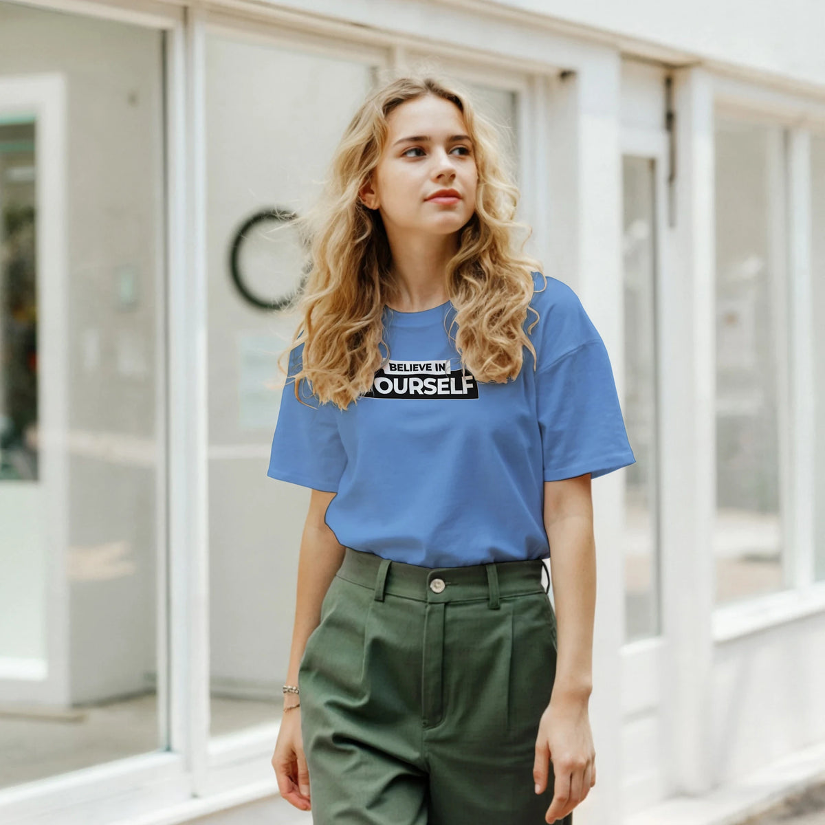 Woman in blue Believe In Yourself retro slogan T-shirt, Urban Palm Trees streetwear style.