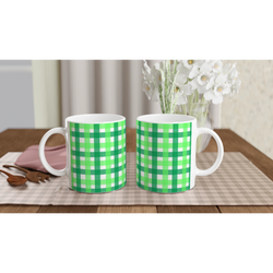 Two green gingham ceramic mugs on a checkered table, a cute coffee cup duo.