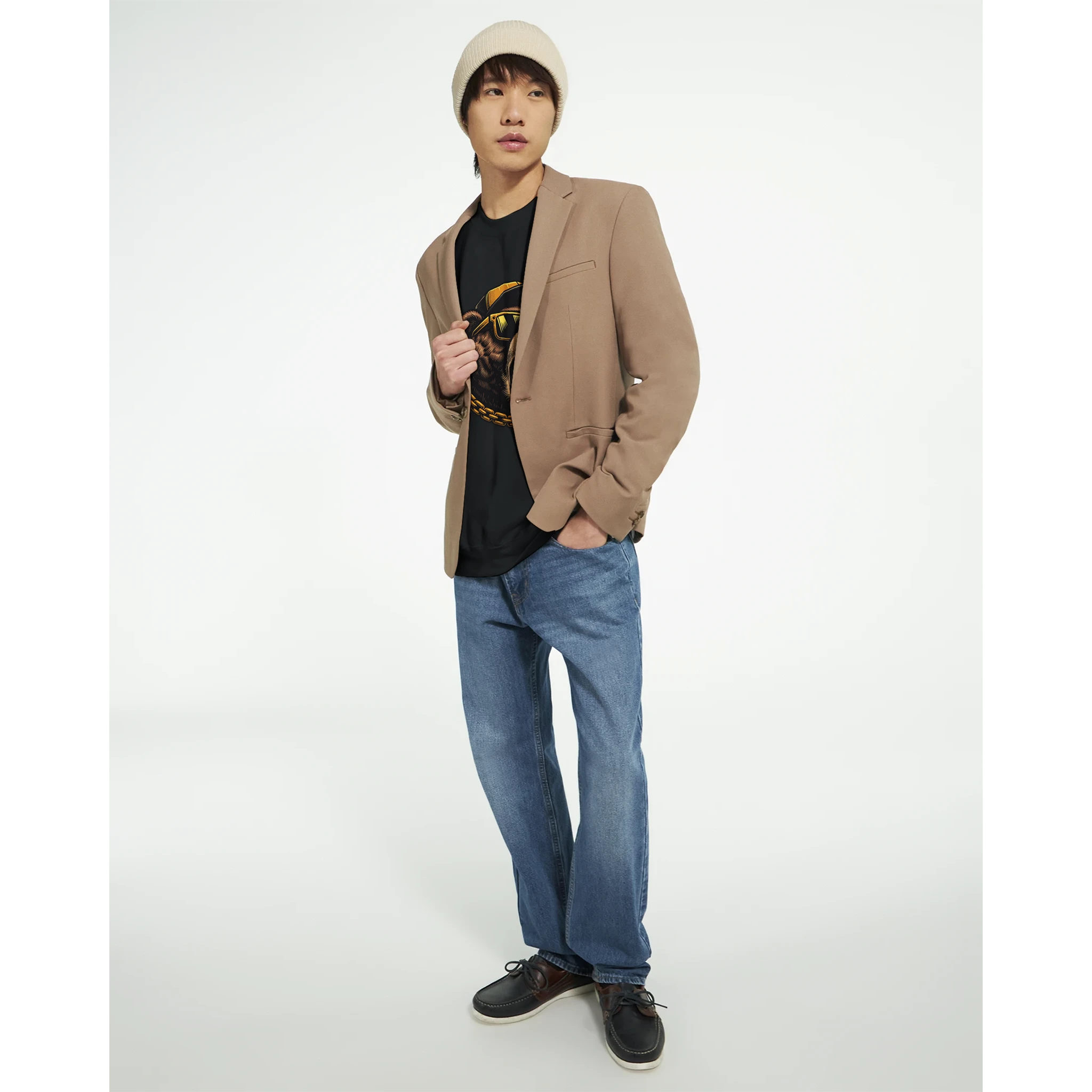 Male model wearing a beige blazer over a Grizzly Bear graphic sweatshirt, soft cotton blend.