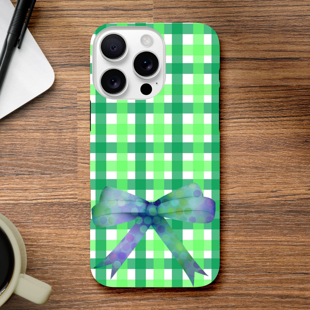 Green gingham iPhone case featuring a blue polka dot coquette bow, designed for tough protection and cute streetwear style.