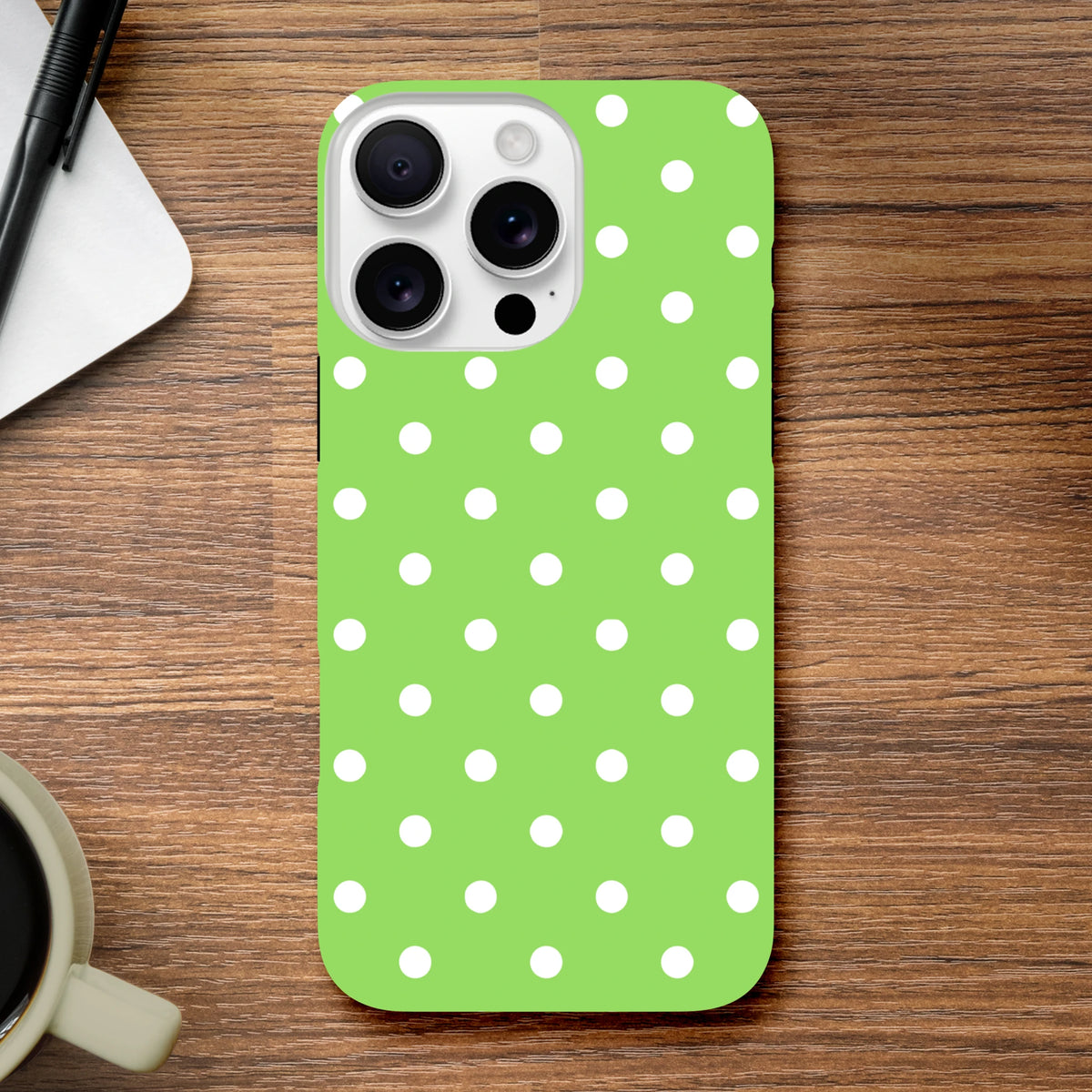 Green and white polka dot tough iPhone case with shock-absorbing TPU core for drop protection, featuring glossy opaque finish and precise cutouts.