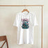 White cotton-blend Japanese Sakura men's graphic T-shirt with pink blossoms and teal pagoda scene on front.