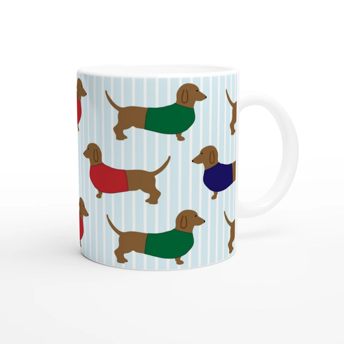 Cute sausage dog ceramic mug featuring dachshund pattern in colorful sweaters on light blue striped background.