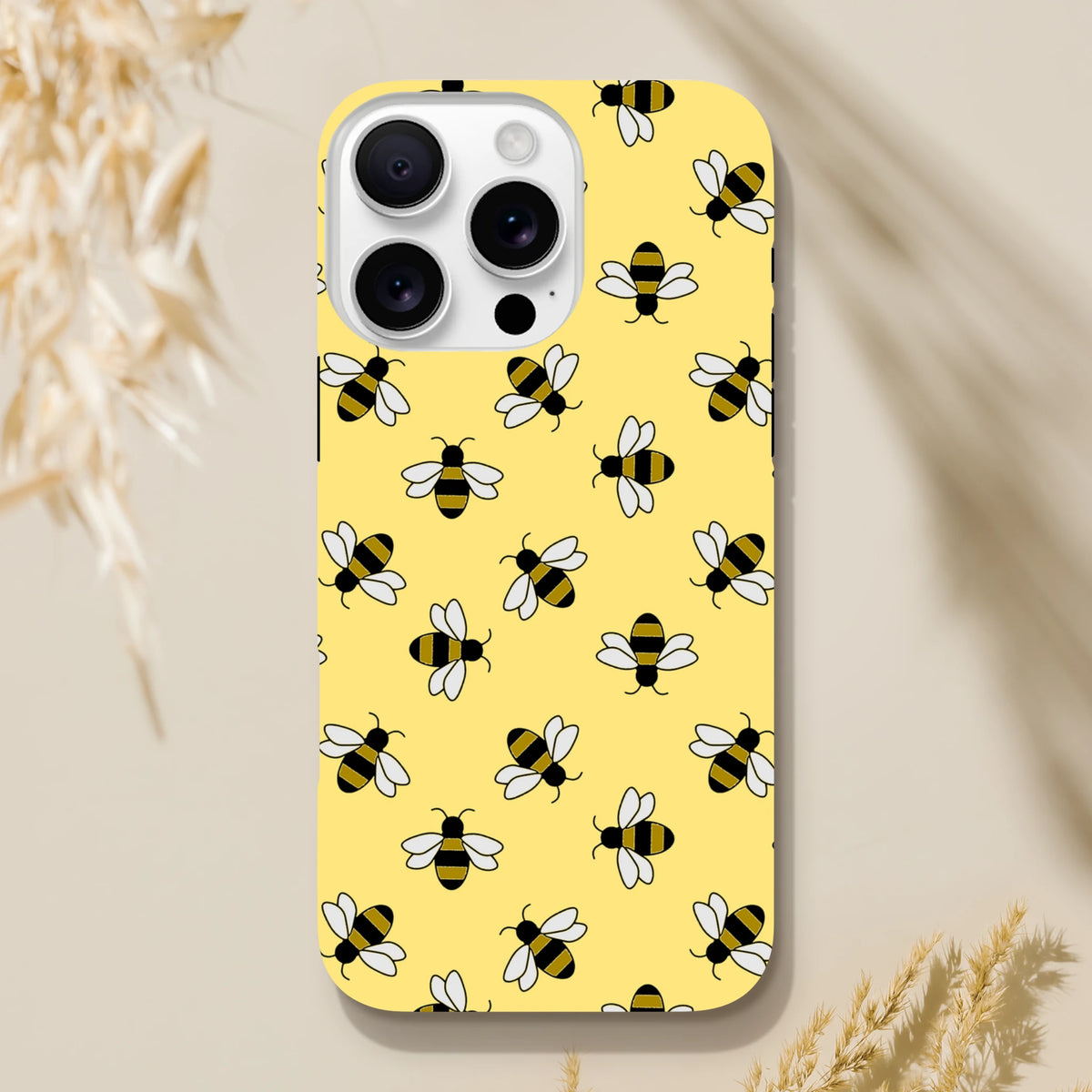 Yellow iPhone case featuring a cute repeating bumblebee pattern on a bright yellow background for everyday protection and style.