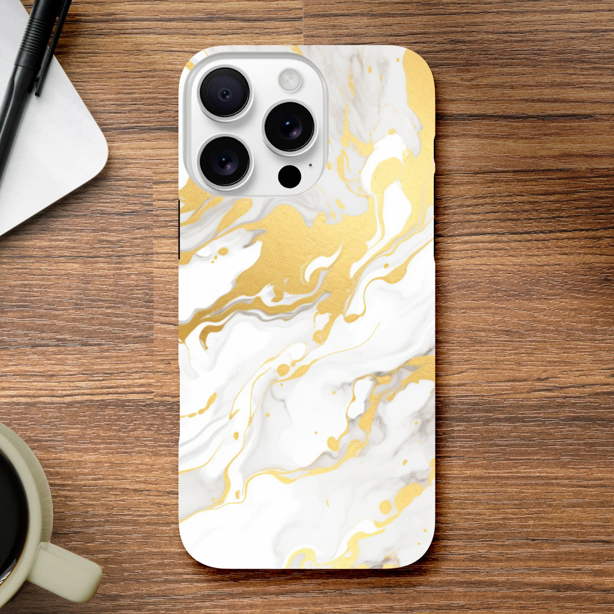Luxury white and gold marble iPhone case with abstract flowing patterns resting on a wooden desk.