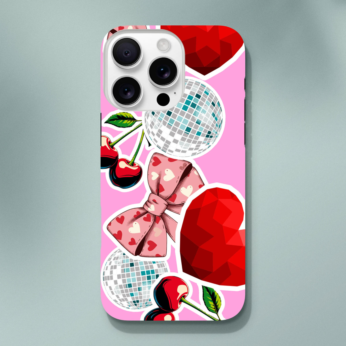 Pink Y2K iPhone case with sticker effect design featuring cherries, heart bow, disco balls, and red gem graphics for tough protection.