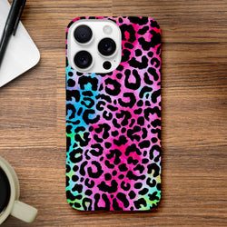Rainbow leopard print tough iPhone case featuring vibrant animal print protection for iPhone 13-16 series on a wooden desk.
