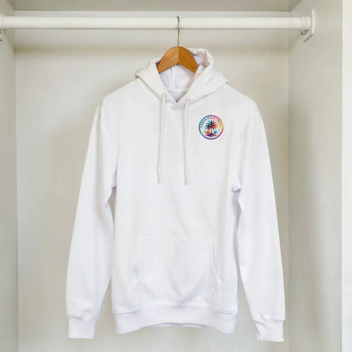 White hoodie with colorful tropical palm tree logo on chest, featuring a front pocket and drawstrings for retro streetwear.