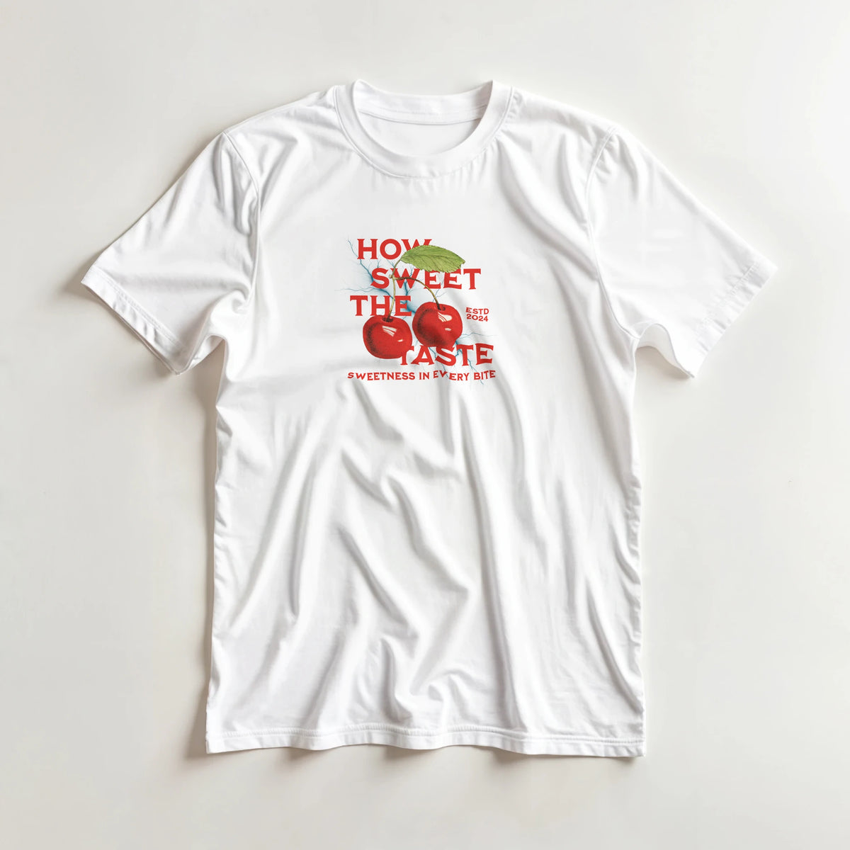 Retro white t-shirt featuring red cherries and "How Sweet The Taste" graphic text for a cute fruit tee look.