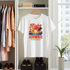 White t-shirt with 'Aloha Hawaii Paradise Island' design hanging in a closet.